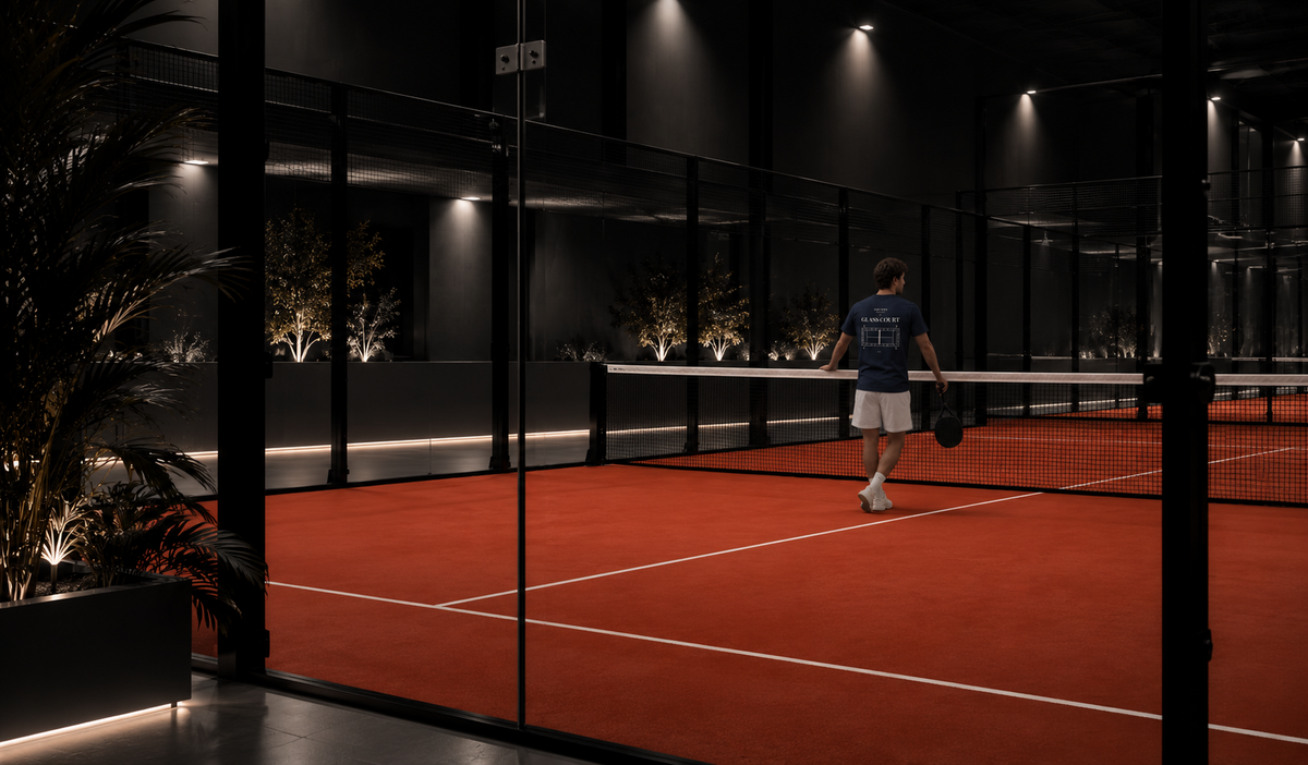Model im SOUVERN Glass Court Tee am Netz eines Padel-Courts bei Nacht